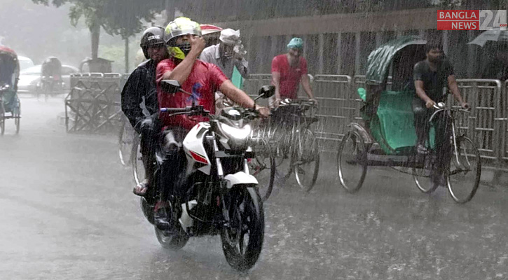 বৃষ্টিতে ভিজে গন্তব্যের পথে মোটরসাইকেল চালক ও আরোহী।  ছবি: শাকিল আহমেদ